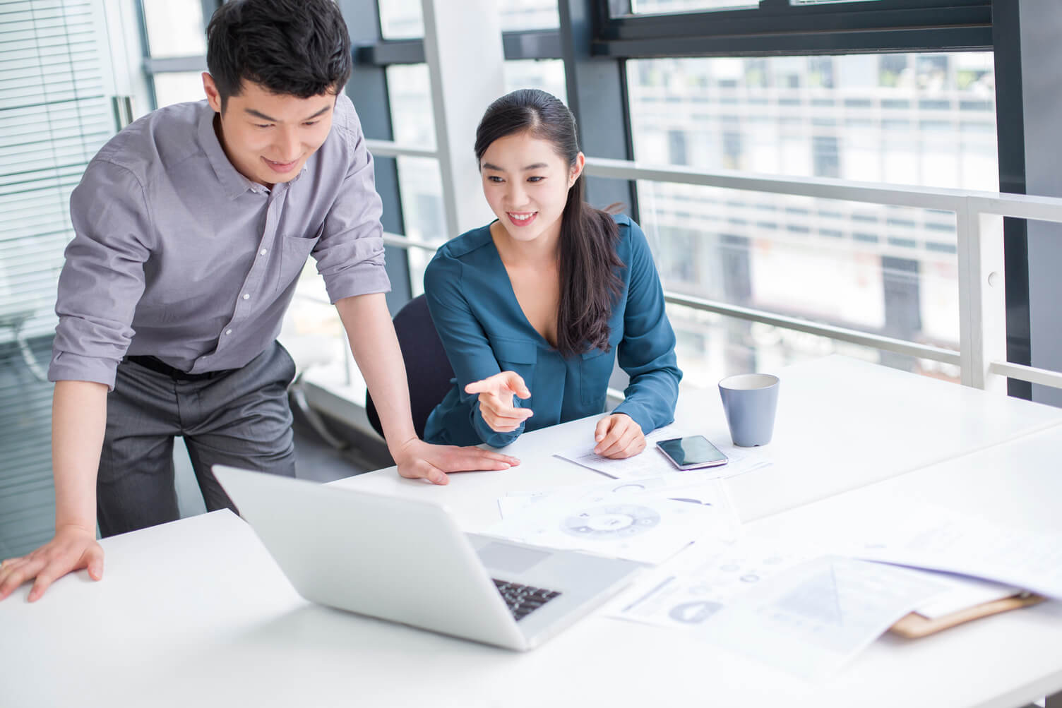 Two people in front of a laptop looking at data